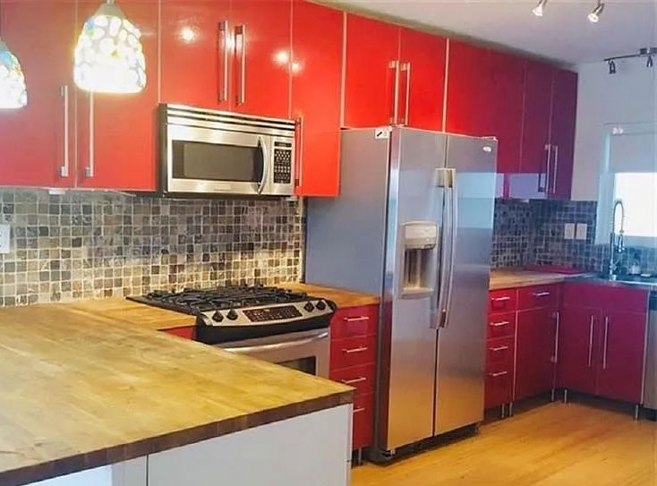 Updated kitchen with red cabinets and stainless appliances